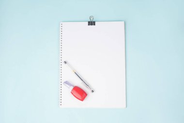Mavi arka planda kalem ve düzeltme kalemli okul defteri, masada spiral defter