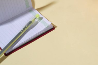 Sarı Arkaplanda Kalem Olan Açık Not Defterinin Yakın Çekimi