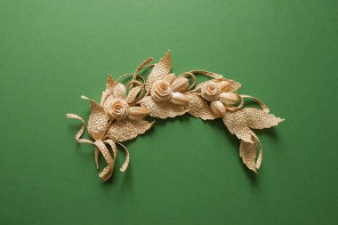 Yapraklı dal samandan yapılmıştır. Saman duvar dekorasyonu. Ürünler samandan yapılmıştır. Yeşil arkaplanda saman süslemesi