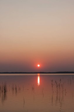 Gölde gün batımı. Güzel bulutlarla dolu akşam gökyüzü gölün suyuna yansıyor.