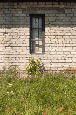 The window of an old brick shed with a wooden frame