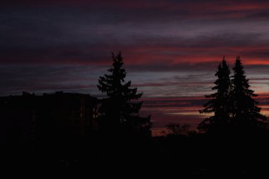 Gün batımı. Akşam gökyüzünde bulutlar. Caddedeki pencereden bak