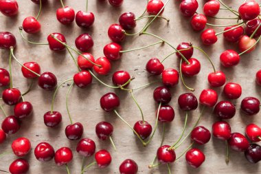 Ripe cherry berries on a beige background with space for text. Top view. Food concept.