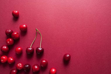 Kırmızı arka planda olgun kiraz meyveleri. Üst Manzara. Yiyecek konsepti. 