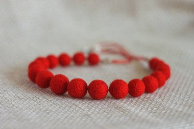 Hafif arka planda kırmızı keçeli yün kolye.