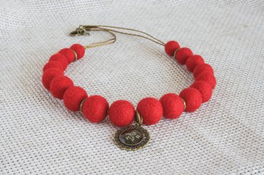 Hafif bir arka planda kolyesi olan bir kolye. Yün Kolye.