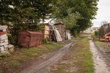 Kırsal toprak yoldan arka bahçeye. Bina çöpleriyle arka bahçe. 