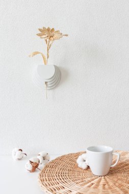 Kurumuş çiçekler için duvar vazosu. Pamuk çiçekleri ve bir fincan kahveyle beyaz arka planda samandan yapılmış çiçekler. Saman duvar dekorasyonu. 