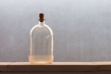 Eski cam şişeler sarı akşam güneşi ışığıyla aydınlatılır. Yakın plan.