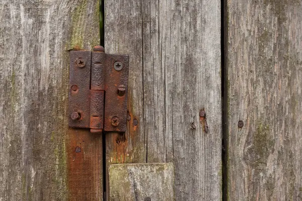 Rusty hinges on rotten doors. Old wooden boards. Background. Copy space