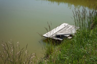 Suyun arka planında eski ahşap iskele