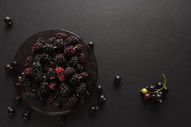 Olgun dut ve üzümlü üzümler siyah arka planda cam bir tabakta. Üst Manzara. Yiyecek konsepti.