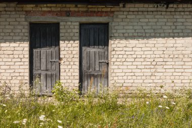 Ahşap çerçeveli eski bir tuğla kulübenin kapısı.