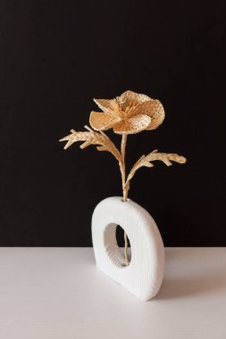 Siyah arka planda samandan yapılmış bir buket çiçekli ahşap bir vazo. Samandan örgü