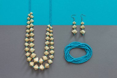 Saman ve boncuk kolye, saman ve boncuk küpeler ve mavi boncuklu bilezik. Mavi boncuklu. Gri arkaplan