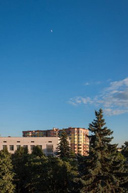 Gökdelenli binaların olduğu pencereden sokağa bak. Mavi gökyüzünün arka planında evler