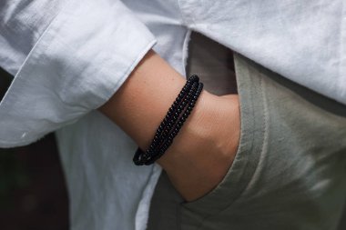 Siyah boncuklu bracele ile bir kadın eli.. 