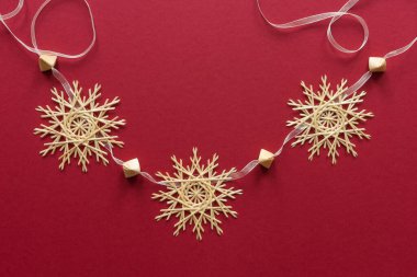 Kar taneleri kırmızı arka planda samandan yapılır. Noel dekoru. Üst Manzara. Samandan örgü örüyorum. Lutsk, Ukrayna