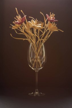 Koyu arkaplanda samandan yapılmış bir buket çiçekli cam bir vazo. Samandan örgü örüyorum. Lutsk, Ukrayna