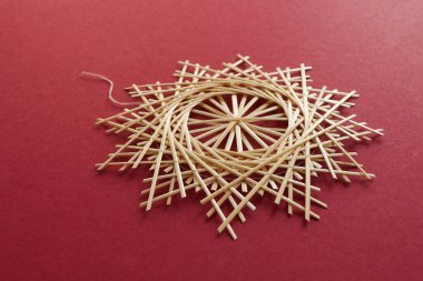 Kar taneleri kırmızı arka planda samandan yapılır. Noel dekoru. Saman Yıldızı. Samandan örgü örüyorum. Lutsk, Ukrayna