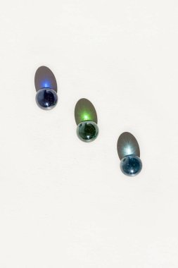 Beyaz arka planda cam renkli toplar. Uzun gölgeler ve kırılma şekilleri. Soyut arkaplan. Yüzeyin derinliği (DOF)