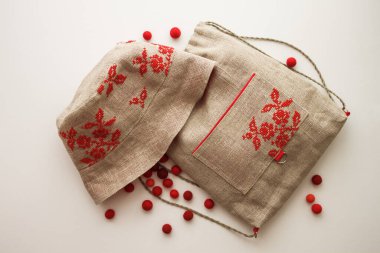 Çocuklu sırt çantası ve panama şapkalı bir hayat. İşlemeli kırmızı süslemeli el yapımı çocuklar. Keten kumaştan yapılmış. Üst düzey seyahat ya da tatil konsepti. Beyaz arkaplan