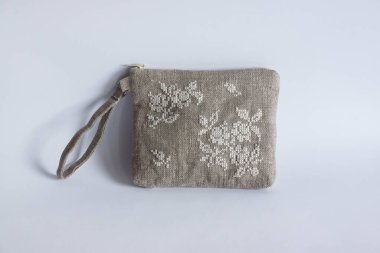 Keten kumaştan yapılmış ve beyaz ipliklerle işlenmiş makyaj çantası. Kişisel bileklik çantası