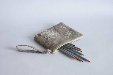 Keten kumaştan yapılmış ve beyaz ipliklerle işlenmiş makyaj çantası. Kişisel bileklik çantası.