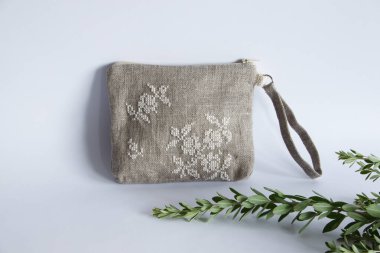 Keten kumaştan yapılmış ve beyaz ipliklerle işlenmiş makyaj çantası. Kişisel bileklik çantası.