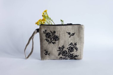 Keten kumaştan yapılmış ve siyah ipliklerle işlenmiş makyaj çantası. Kişisel bileklik çantası.