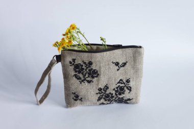 Keten kumaştan yapılmış ve siyah ipliklerle işlenmiş makyaj çantası. Kişisel bileklik çantası.