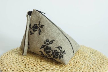 Keten kozmetik çanta ketenden yapılır ve siyah bir nakışla süslenir. Hafif arkaplan