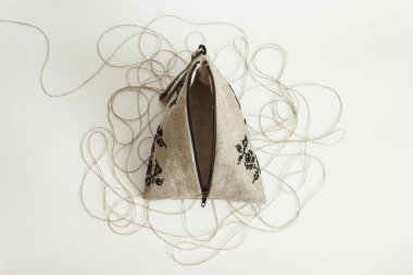 Keten kozmetik çanta ketenden yapılır ve siyah bir nakışla süslenir. Hafif arkaplan