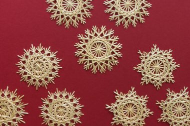 Kar taneleri kırmızı arka planda samandan yapılır. Noel dekoru. Saman Yıldızı. Üst Manzara. Samandan örgü örüyorum. Lutsk, Ukrayna