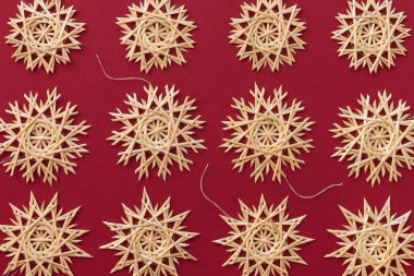 Kar taneleri kırmızı arka planda samandan yapılır. Noel dekoru. Üst Manzara. Samandan örgü örüyorum. Lutsk, Ukrayna