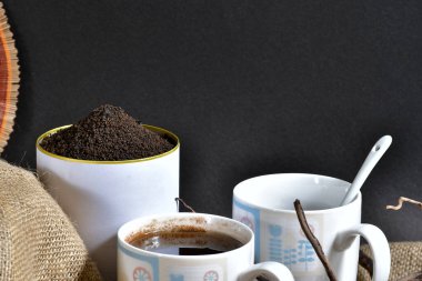 İki beyaz fincan siyah çay ve konserve kutusuyla dolu bahçe taze organik çay yaprakları reklam, afiş, kitap örtüsü veya herhangi bir ambalaj için mükemmel bir şekilde çay kutusunda sunulacak.