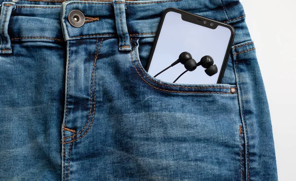 Κινητό Τηλέφωνο Λευκή Οθόνη Στην Τσέπη Του Blue Jeans Ακουστικά — Φωτογραφία Αρχείου