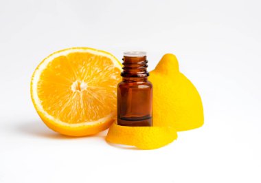 Cam şişe limon özü aroma yağı ve beyaz arka planda izole edilmiş taze organik limon meyvesi..