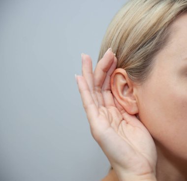 Kulak ağrısı ya da boyun ağrısı olan bir kadın. Bir kadının boğazında şiddetli ağrı. Kadın kulağının arkasında el ele tutuşuyor. Acının yerini gösteren okuma noktalı konsept fotoğraf.