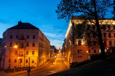 Brno, Czech Republic - Night illuminated city street at sunset with old buildings and church.