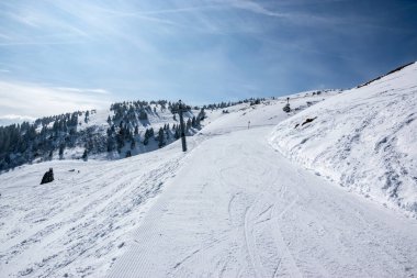 Avusturya Alplerinde teleferik direği ve açık hava koşullarıyla kayakçılar için hazırlanmış bir yamaç..