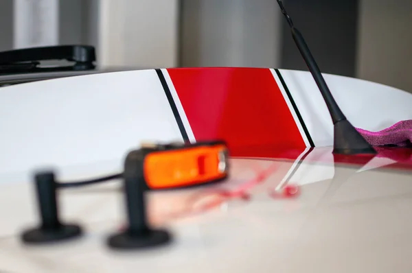 stock image Detail on the trunk of the car during the installation of red foil stickers. Fast stripe decals on car.