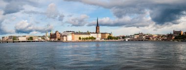 Stockholm, İsveç - 20 Temmuz 2015: Gamla Stan 'in tarihi merkezi ile rıhtımın panoraması. Şehirdeki deniz suyu ve köprüler.