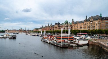 Stockholm, İsveç - 20 Temmuz 2015 Limanı ve gemileri olan liman. Şehir merkezinde ağaçlar ve eski miras binaları olan bir cadde. Deniz suyu kanalı.