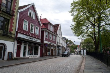 Bergen, Norveç - kaldırımlı yolu olan cadde ve şehir merkezinde dükkanları olan ahşap evler.