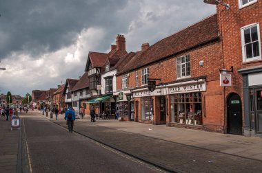 Stratford-upon-Avon, İngiltere - Şehrin merkezinde dükkanları ve kaldırımlı bir caddesi olan tuğla evler.
