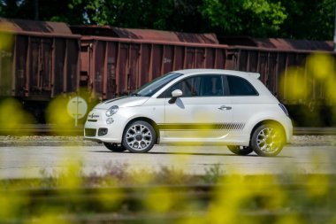 Brno, Çek Cumhuriyeti - 20 Mayıs 2023: Küçük beyaz bir İtalyan arabası eski ütülenmiş vagonların önüne park edilmiştir.. 