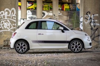 Brno, Çek Cumhuriyeti - 20 Mayıs 2023: Beton boyalı sütunları olan küçük beyaz bir İtalyan arabası otoban köprüsünün altına park edildi.