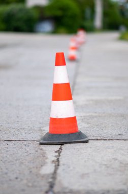 Beyaz kırmızı uyarı külahları yolda. Şehirdeki yolda inşaat işi..