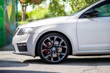 Brno, Çek Cumhuriyeti - 13 Ağustos 2023: Beyaz Çek hızlı aile arabası Skoda. Modern bir arabanın yan ve ön tekerlekleri..